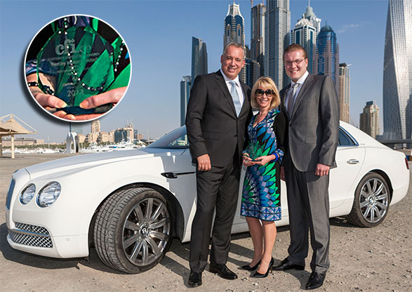 Janice Hinson, Marketing Manager for Bentley - Middle East, receiving an award from CFI.co (Tor Svensson, left, and Marten Mark, right) in front of the new Flying Spur