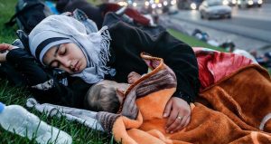 UNDP Turkey/Huseyin Sari/GFSD Golcuk. A homeless mother sleeping with her baby on a grass patch near highway.